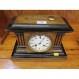 A mid Victorian walnut and ebonised mantel clock of architectural form with fluted sides, the enamel