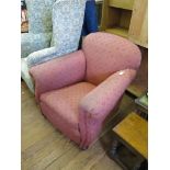 A 1930's uphostered armchair, the rounded back and scroll arms on oak bun feet and castors