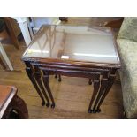 A nest of three mahogany tables, with inset glass tops and cabriole legs, 53cm wide