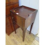 A mahogany pot cupboard, the three quarter gallery over a door on square tapering legs, 36cm wide
