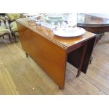 A George III style mahogany drop leaf table, the rectangular top over chamfered legs with brass