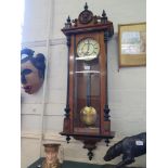 An early 20th century walnut and ebonised Vienna wall clock, the pediment with mask and finials over