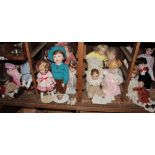 A collection of twenty-two dolls, mostly modern with bisque heads, including Shirley Temple doll,