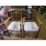 A pair of early 20th century oak carver chairs, the shaped top rails over lattice backs and scroll