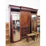 An Edwardian inlaid and chevron banded breakfront wardrobe, the moulded cornice over an oval