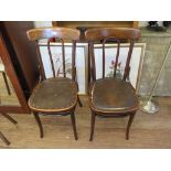 A pair of Bentwood cafe chairs, with broad top rails and Rexine covered solid seats, stamped Made in