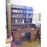 An oak tambour top desk, with shelf superstructure, the roll top enclosing a fitted interior over