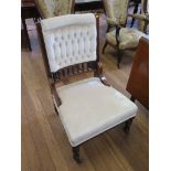 An Edwardian walnut nursing chair, the button upholstered back with spindle turned rail above an