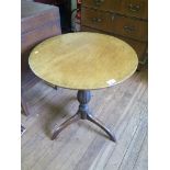 A George III mahogany snaptop tripod table, the circular top over a scale carved baluster stem on