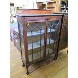 An oak bowfront display cabinet, the gadrooned edge over a pair of ogee glazed doors on cabriole