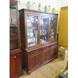 A reproduction mahogany bookcase, with dentil cornice over three astragal glazed doors, three frieze