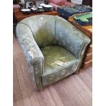 A 1920's upholstered armchair on bun feet and castors