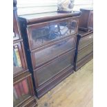 A Globe Wernicke oak graduated three tier bookcase, with glazed fall fronts, 86cm wide, 115cm high