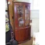 A pair of yew-wood corner display cabinets, each with dentil cornice over a pair of glazed doors and