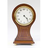 An Edwardian mahogany and boxwood strung balloon shape mantel timepiece, with enamel dial and
