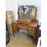 A walnut dressing table with bevelled shaped mirror over five drawers on cabriole legs and club