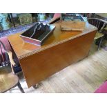 A George III style mahogany drop leaf table, the rectangular top over chamfered legs with brass