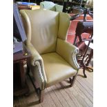 A George III style mahogany and leather upholstered wing arm chair, on chamfered square legs