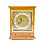 An early 20th century mahogany mantel clock, the shaped top carved with flowerhead and foliage