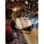 A pair of ash and elm captain's chairs, with turned spindles and pierced vase form splats on