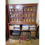 A mahogany bookcase, the top section with two glazed doors over open shelves on bracket feet,