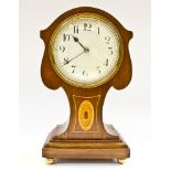 An Edwardian walnut and boxwood lined mantel timepiece, the shield shaped waisted case with inlaid