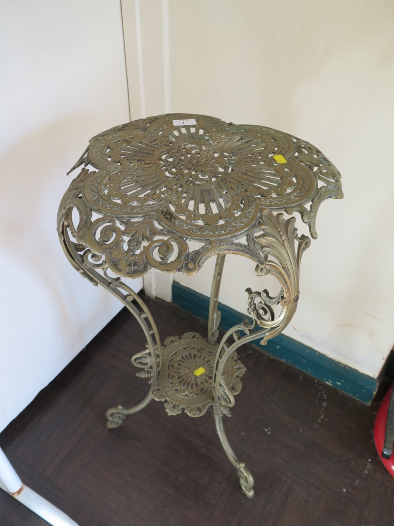 A continental cast brass table, with sexfoil pierced top and pierced cabriole legs joined by an