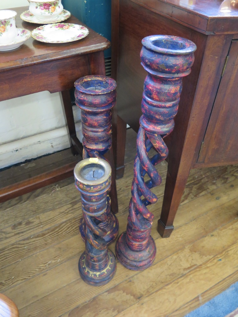 A set of three polychrome wooden standing candlesticks, graduated, each with intertwined barleytwist