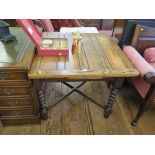 An oak draw-leaf table, on barley -twist legs joined by cross stretcher