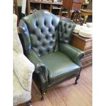 A leather upholstered wing armchair, on stained cabriole legs and club feet