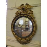 A Regency style giltwood circular wall mirror, with ball applied frame surmounded by an eagle