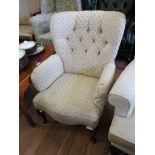 A Victorian style button upholstered armchair with cabriole legs