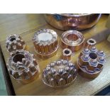 A collection of eight Victorian copper jelly moulds, largest 15cm diameter