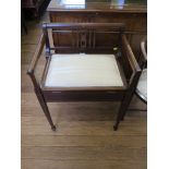 An Edwardian mahogany and boxwood lined piano stool, the raised back with maple panels over a hinged