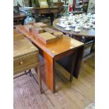 A George III style mahogany drop leaf table, the rectangular top over chamfered legs with brass