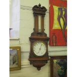 An Edwardian carved walnut Aneroid barometer retailed by Maple & Co. Ltd. London, the swan neck