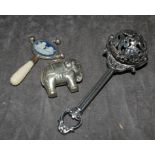 A silver 925 baby rattle with cherubs and three bells, together with silver plated elephant and