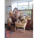 A large collection of various cane, rush and wicker baskets, including child's chair, cot and