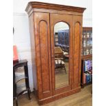 A Victorian pitch pine wardrobe, the moulded cornice over a mirrored door and panelled door on a