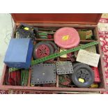 Collection of Meccano, with green and red parts, including some tins, clockwork movement and an E20R