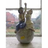 A Lladro figure for UNICEF, two children sitting on a globe, 26cm high with original box