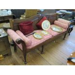 A late George III mahogany hall settee, the shaped panelled back over upholstered scroll arms on