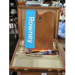 A Rowney paint palette and case with a collection of artists brushes