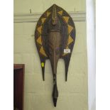 An African carved softwood elongated mask with brass mounts, 61cm long