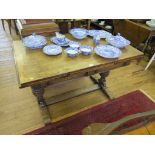 An oak draw leaf table, the rectangular top with carved cup and cover supports on bracket feet