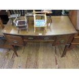 An Edwardian mahogany bowfront dressing table, the central drawer and kneehole flanked by deep