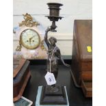 An Edwardian bronze candlestick in the form of a scantily clad lady on a square cavetto base, 30cm