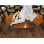 A yew-wood veneer oval coffee table with quadruped base, 111cm wide