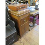 A 1930s oak gramophone case, the hinged lid over two pairs of cupboard doors on turned legs 45cm