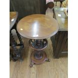 A Victorian mahogany wine table, the circular top on a turned stem with spindle galleried undershelf